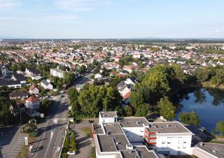 Vue aérienne d'une petite ville. Au premier plan, un petit plan d'eau