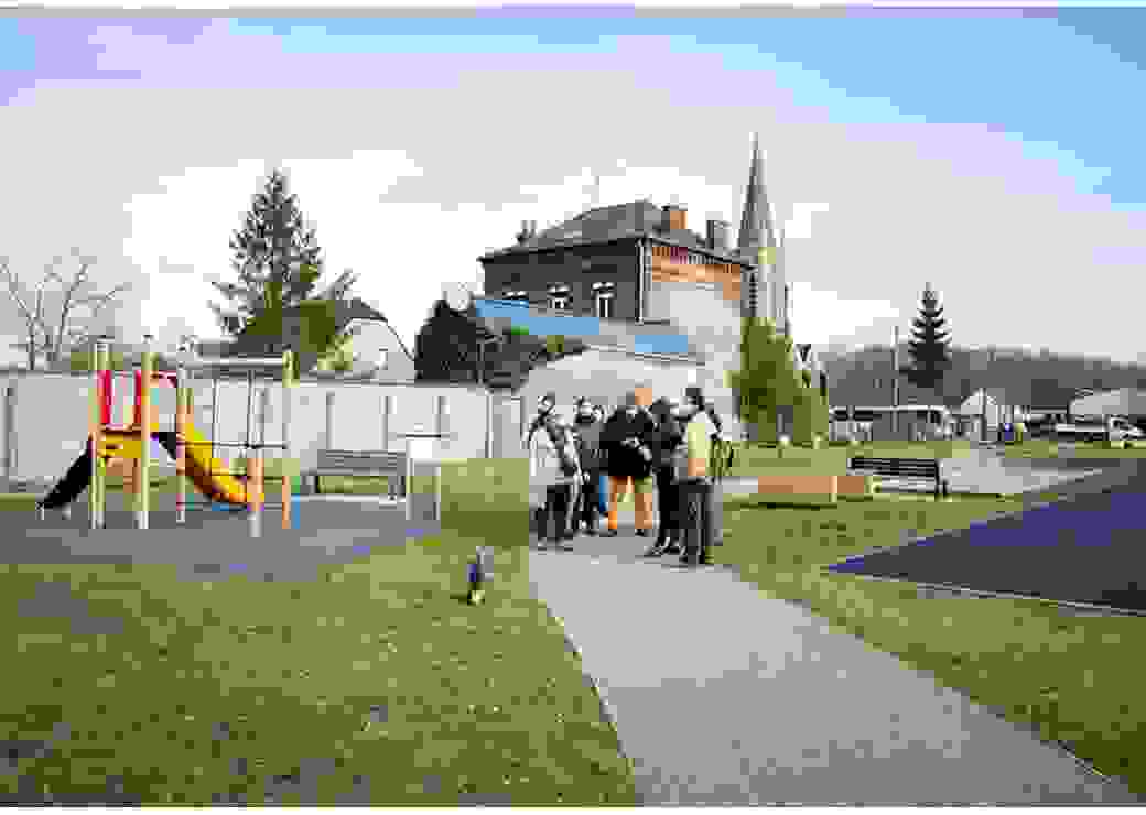 Dans un jardin public, à droite des jeux pour enfants, au milieu un sentier goudronné sur lequel se situe un groupe de personnes portant des masques chirurgicaux
