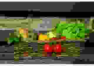 Photographie type nature morte, d'un panier en osier contenant des légumes