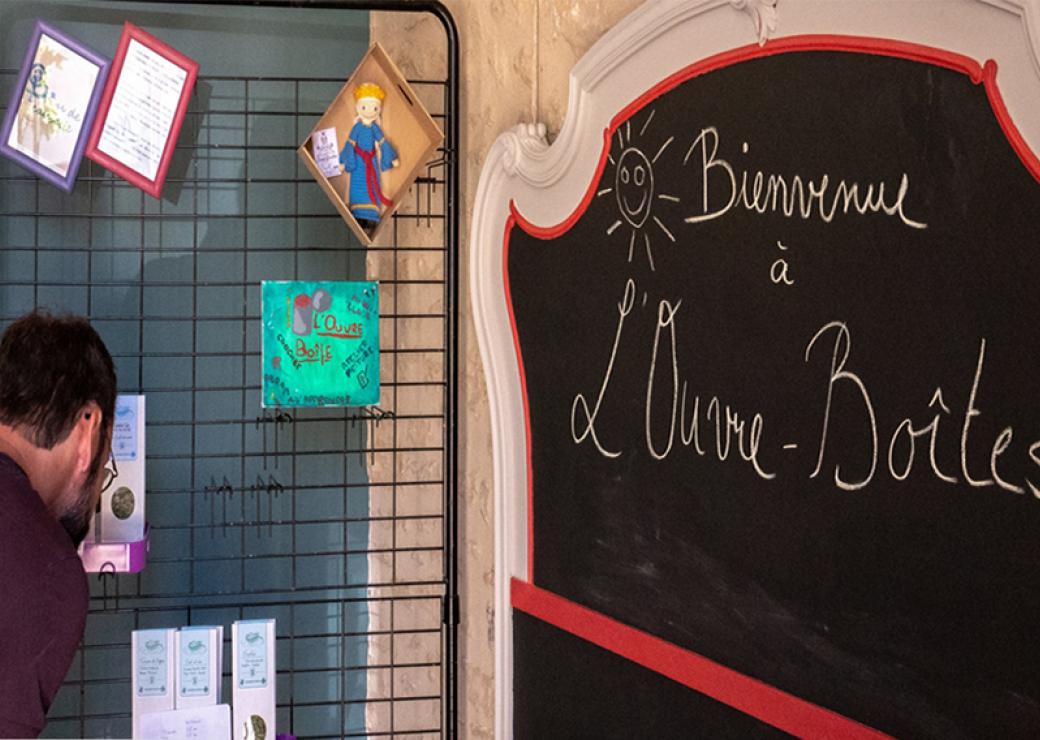 Un homme regarde un panneau d'affichage devant un tableau où est écrit bienvenue à l'ouvre-boîtes