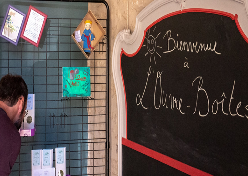 Un homme regarde un panneau d'affichage devant un tableau où est écrit bienvenue à l'ouvre-boîtes