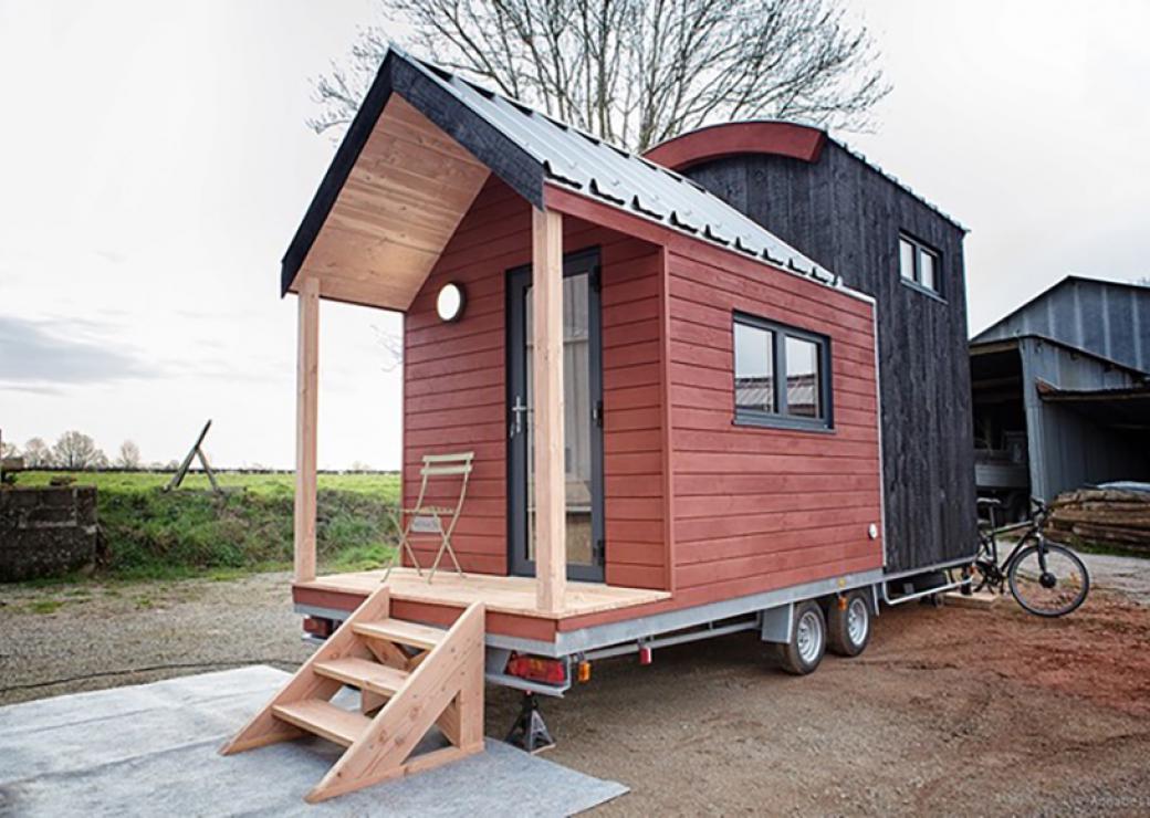 Sur un sol en terre battue, une petite maison de bois, montée sur roues, est installée