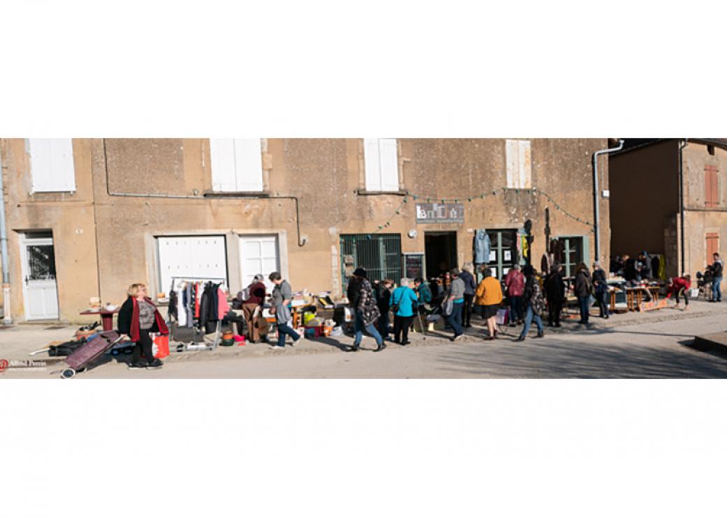 Dans une rue de village, vue panoramique d'un groupe de personnes