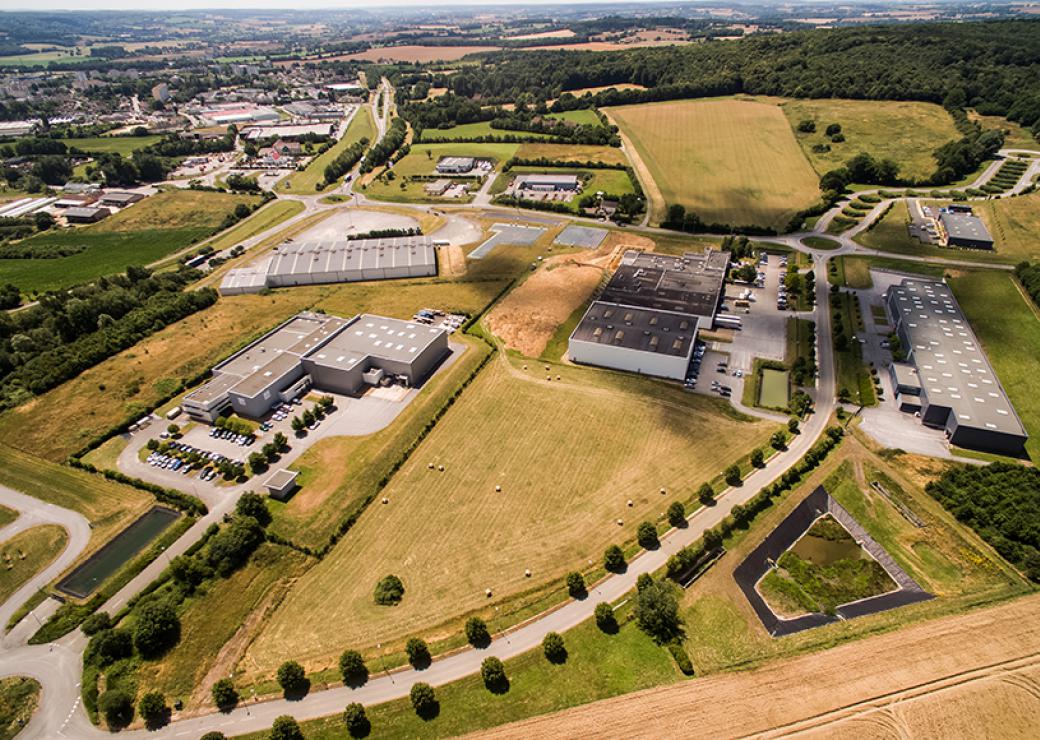 Vue aérienne de bâtiments industriels entourés de champs