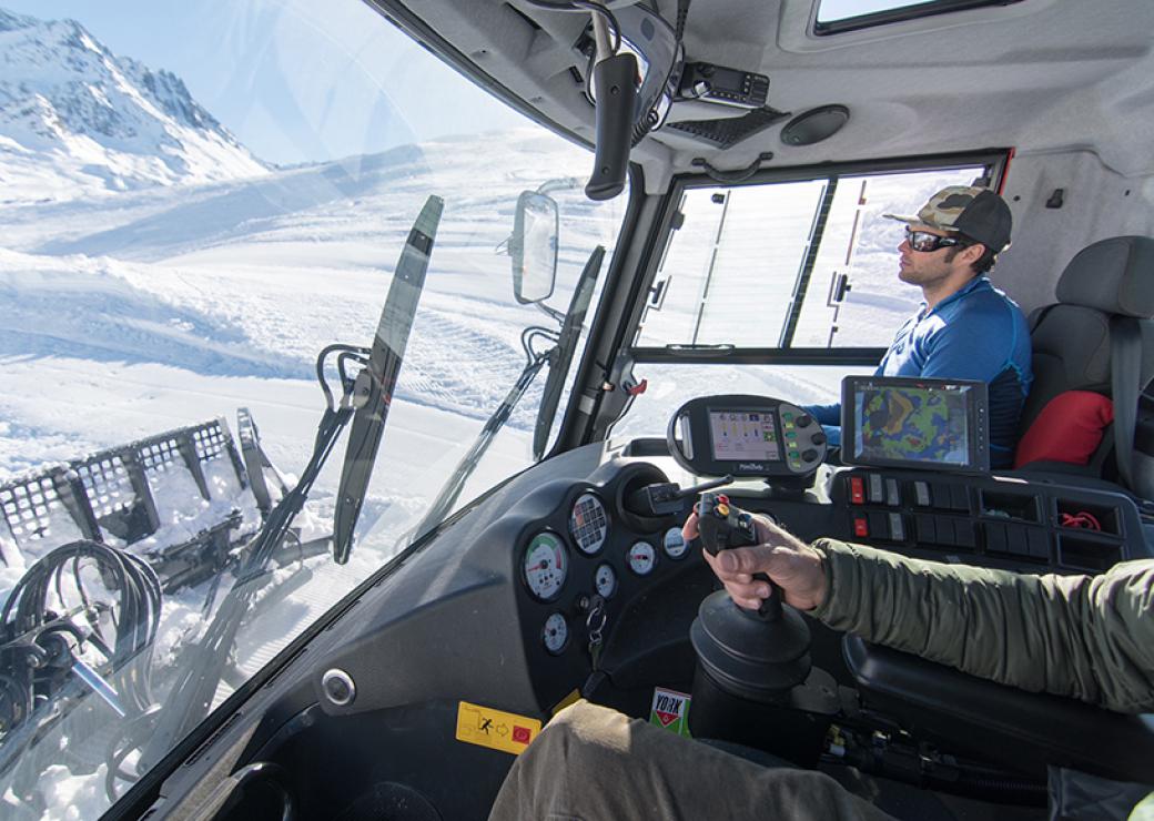 Vue sur les pistes enneigées, depuis la cabine de conduite d'une dameuse