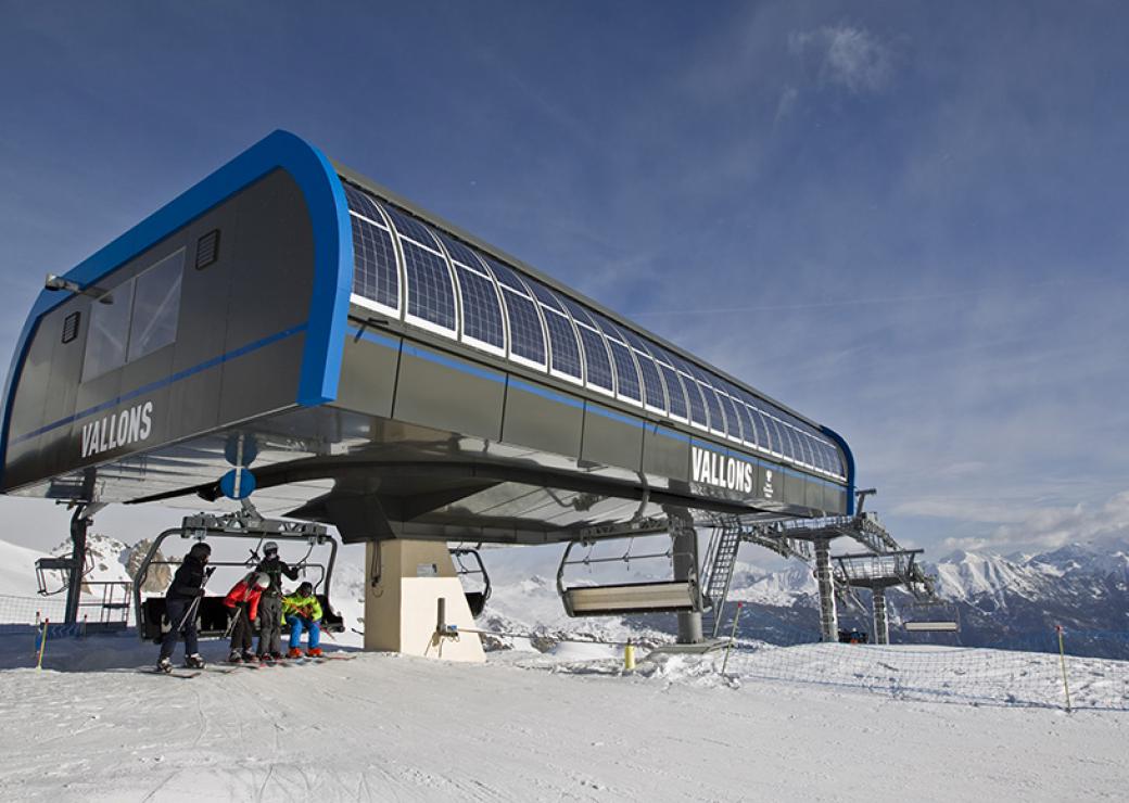 En montagne, plan large d'une station de télésièges équipée de panneaux solaires