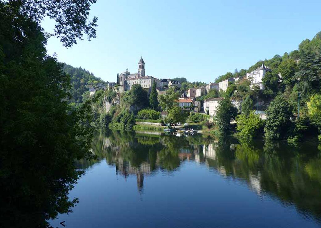 Depuis une étendue d'eau, vue sur un petit village niché dans la verdure