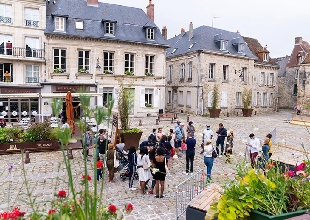 Un groupe d'une trentaine de personnes sur une place publique dans un centre historique