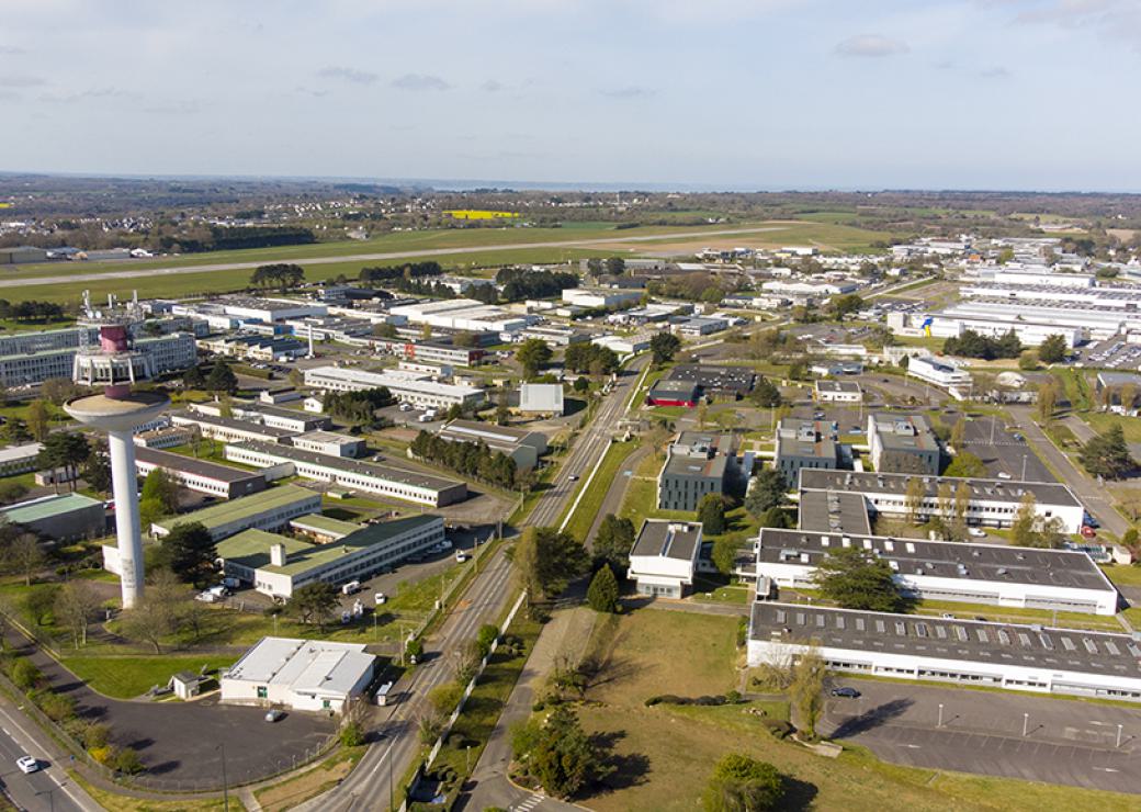 Vue aérienne d'une zone d'activité, avec des hangars et des bâtiments aux toits plats