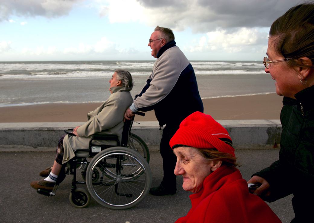 personnes âgées en fauteuil roulant en promenade au bord de mer 