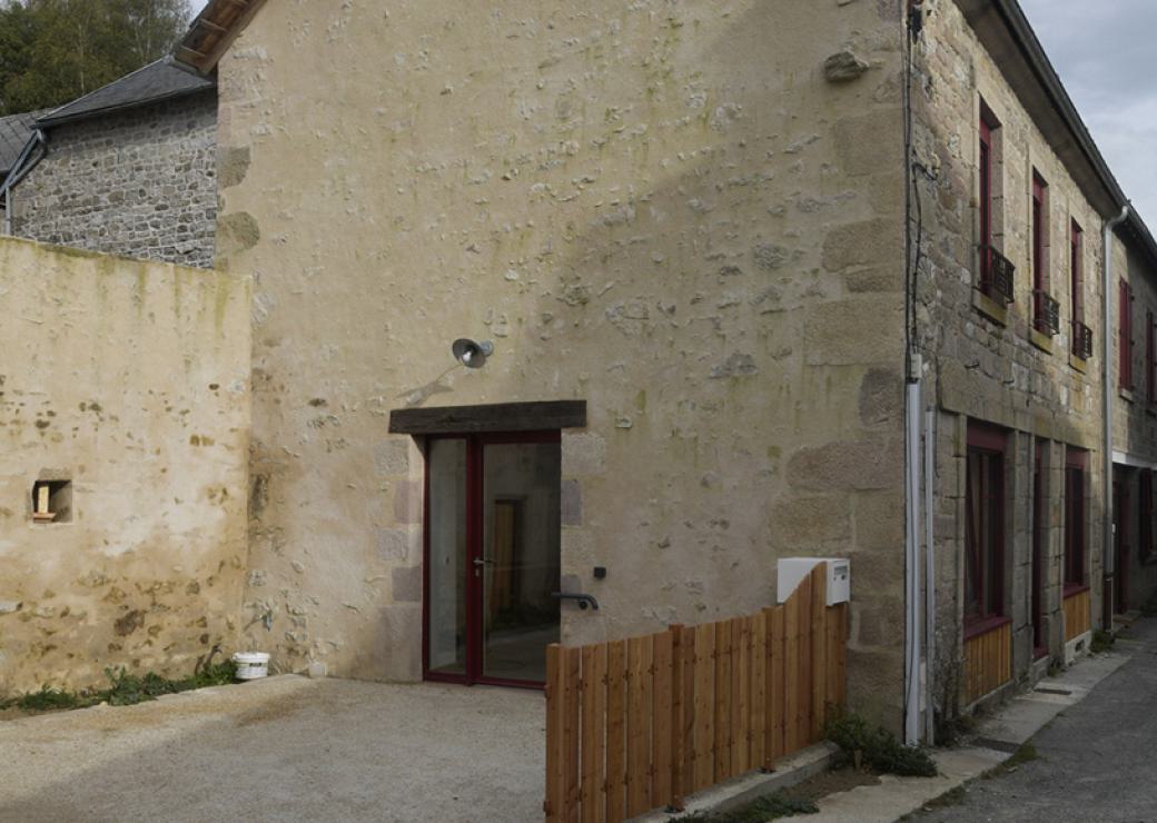 Dans une ruelle, une maison de village en pierres apparentes