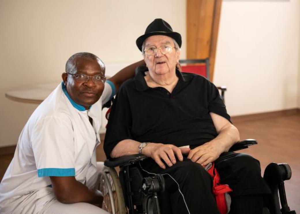 Un personne de santé avec une personne agée en fauteuil roulant