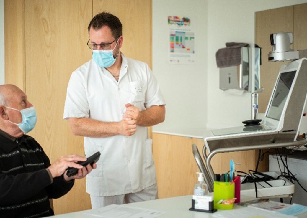 Un infirmier et un patient, devant un ordinateur