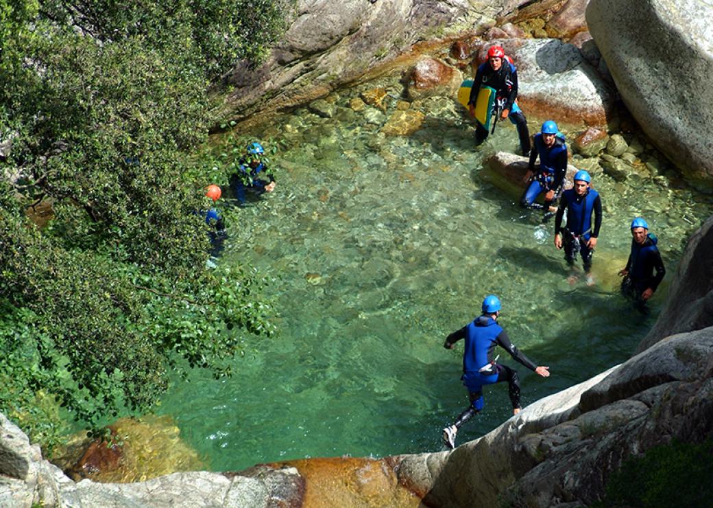 Des personnes en combinaison de plongée sont immergés dans une eau turquoise