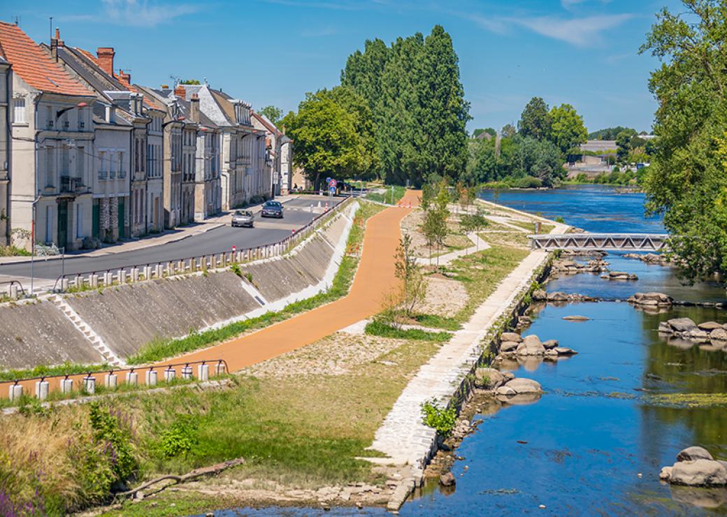 Une rivière bordée d'une promenade et de maisons