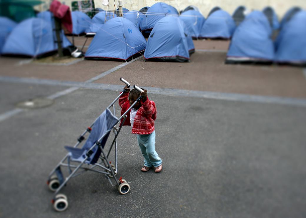 un epetite fille joue au milieu des tentes