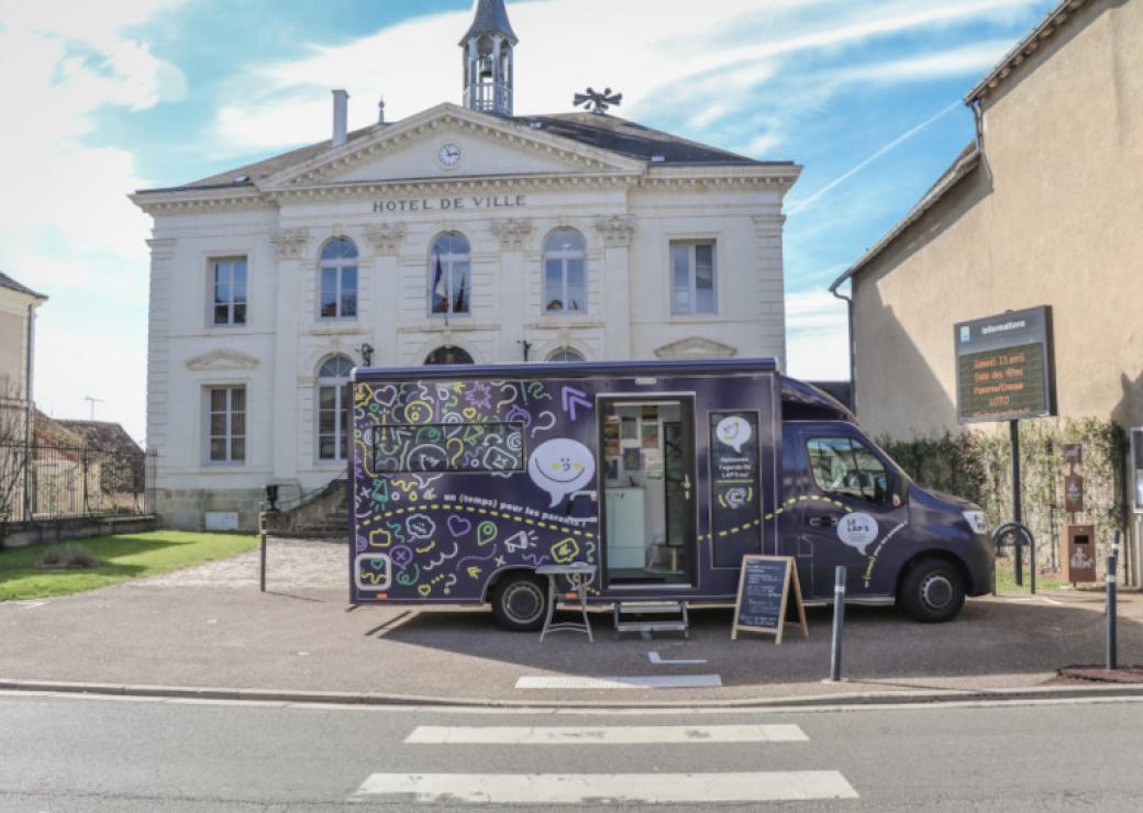 Un camion noir garé devant un bâtiment classique sur lequel on peut lire "Hôtel de Ville"