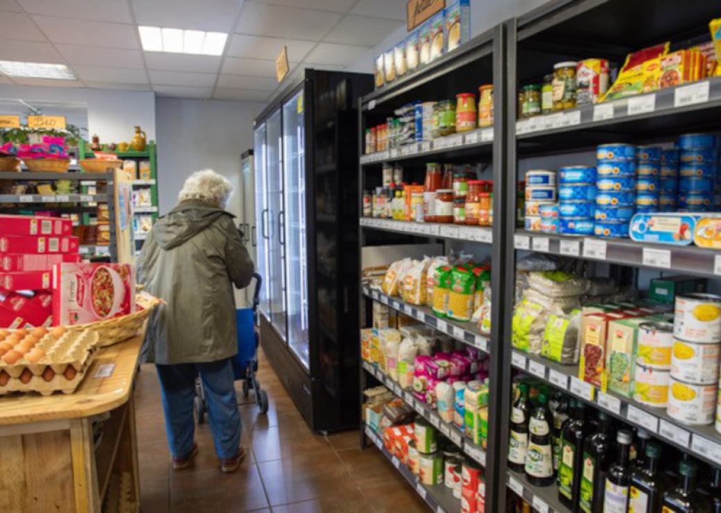 Une personne pousse un caddie dans des rayons de supermarché