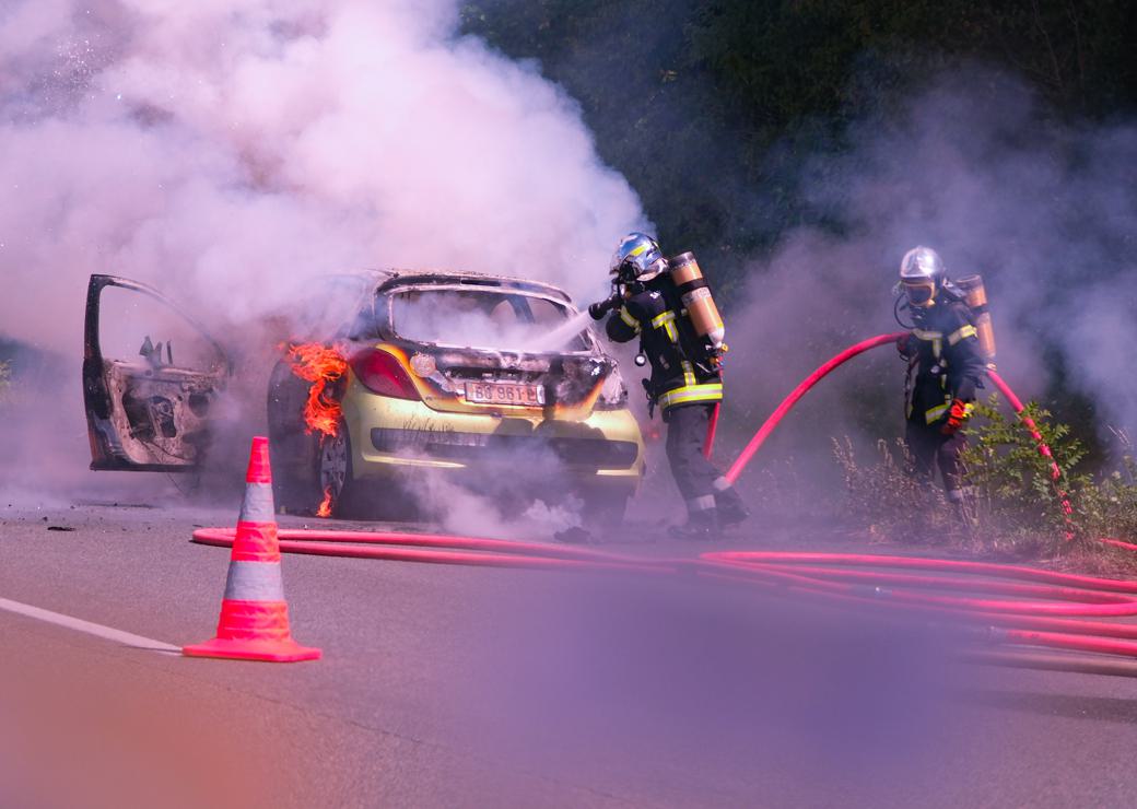Des pompiers éteignent l'incendie d'une voiture sur l'autoroute