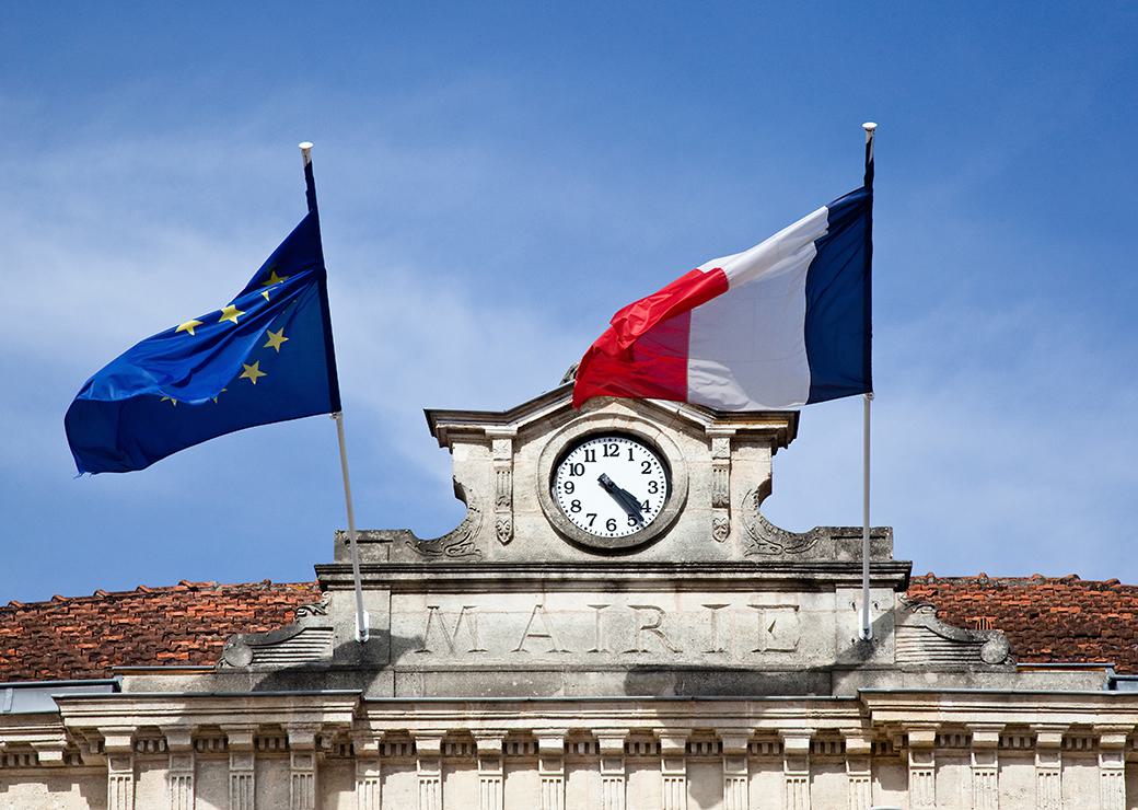 Façade d'un emairie avec un drapeau Français et européen