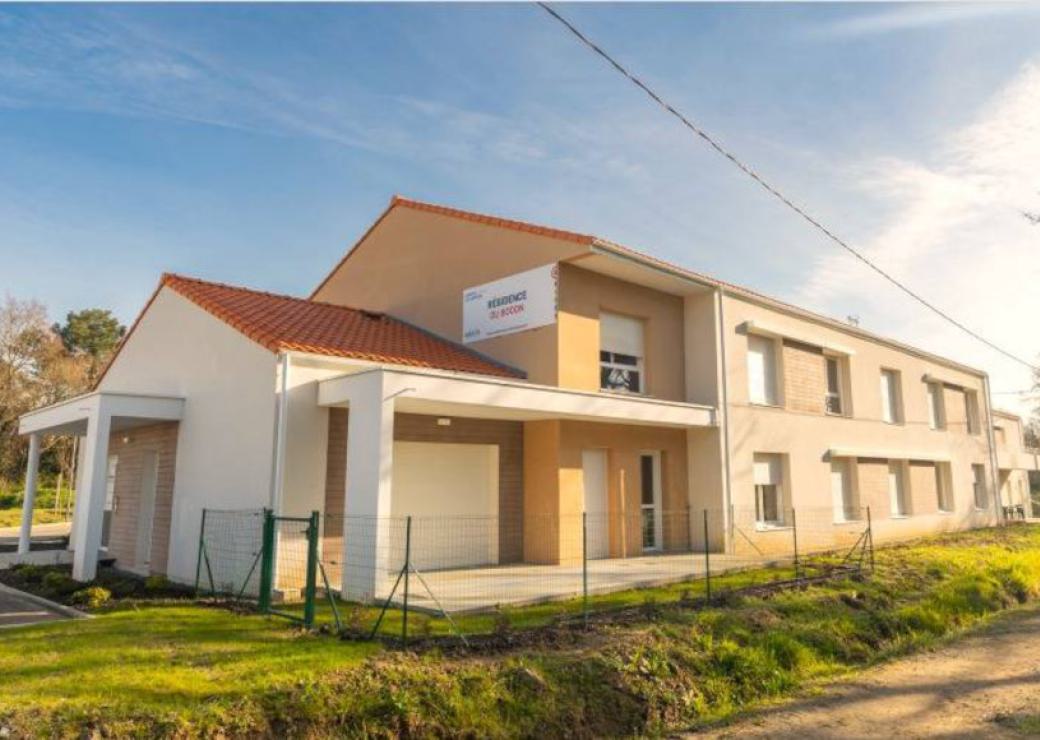 Une maison de deux étages de construction récente, avec de nombreuses fenêtre