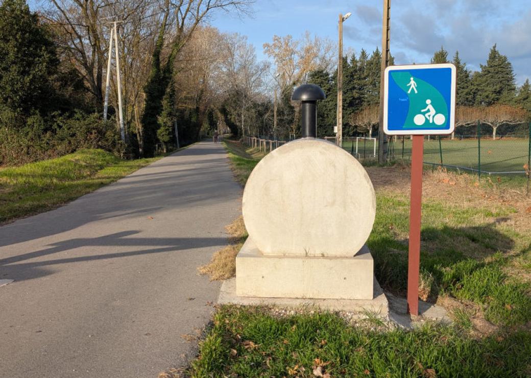 Une petite route goudronnée précédée d'un panneau autorisant cyclistes / piétons