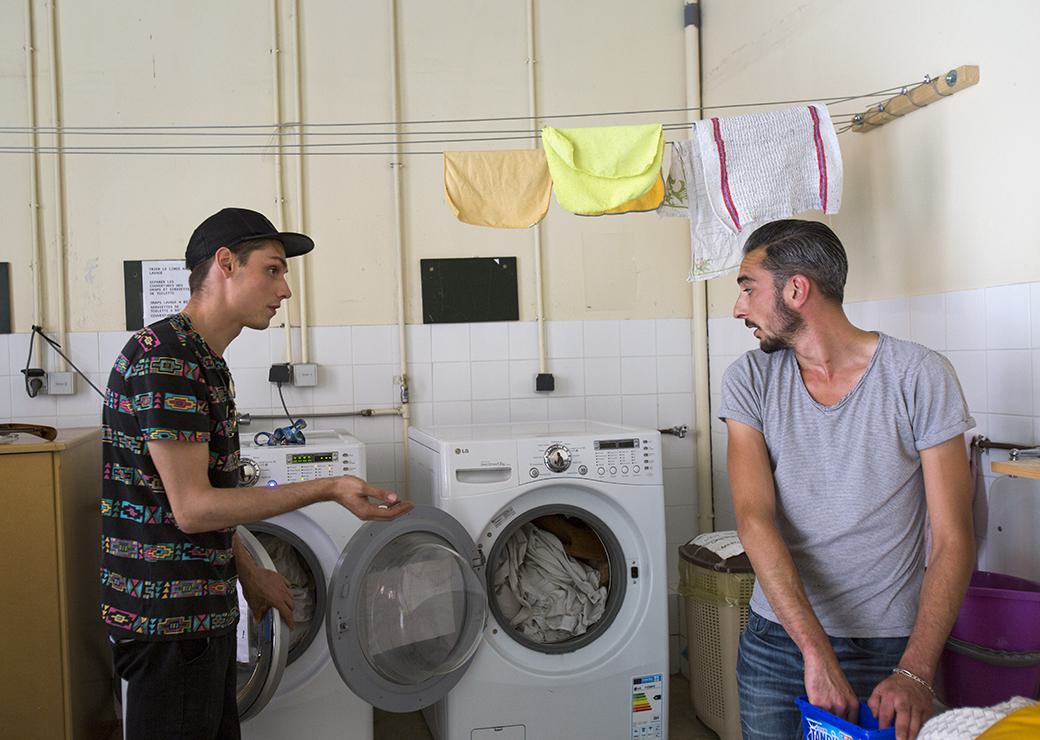 deux jeunes font leur lessive dans une résidence 