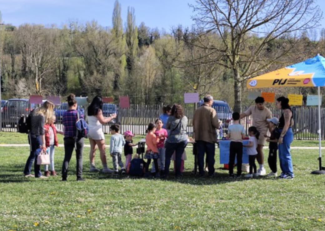Des personnes se rassemblent autour d'un parasol sur une pelouse