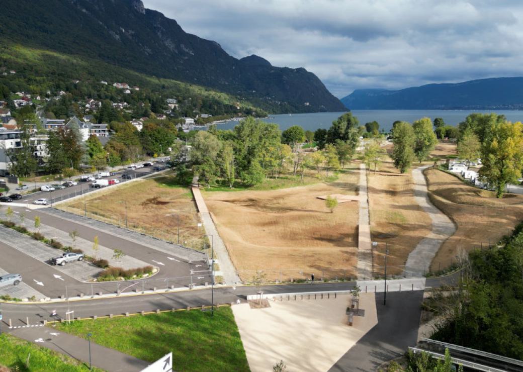 Vus du ciel: un parc, un parking, et en fond une colline et une étendue d'eau
