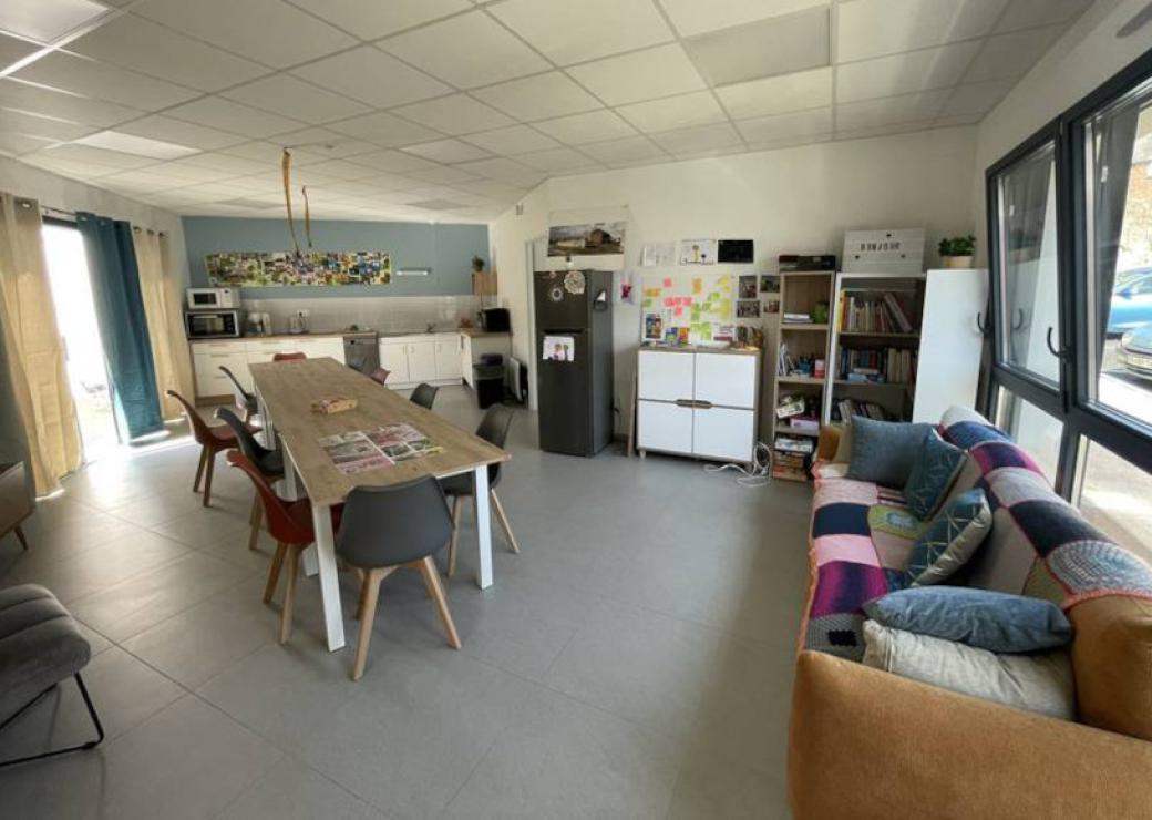 Un salon - cuisine, équipé de table et canapé