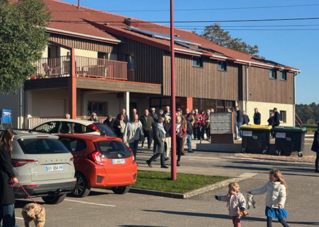 Un groupe de personnes sort d'un bâtiment d'habitation