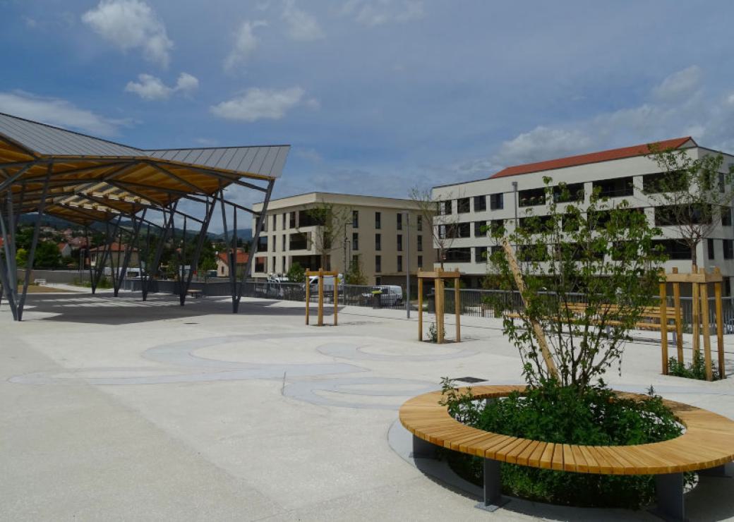 Photo d'un quartier nouveau, avec une place, des bâtiments d'habitation, une halle et des espaces verts