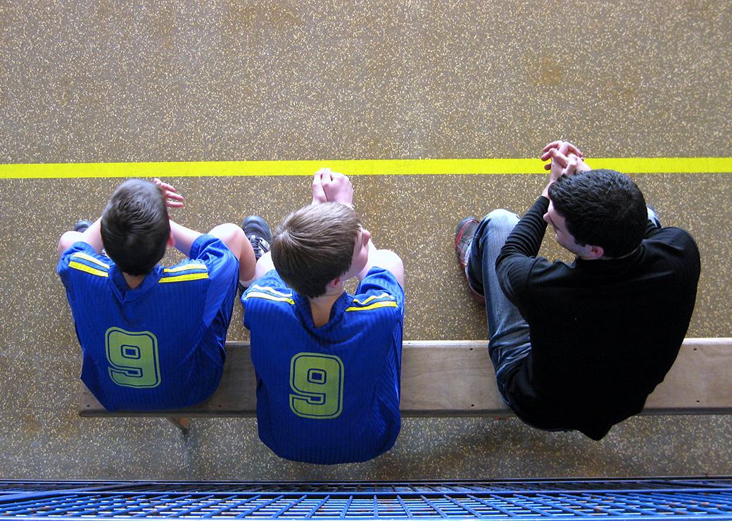 2 garçons sur le banc de touche lors d'un match de handball