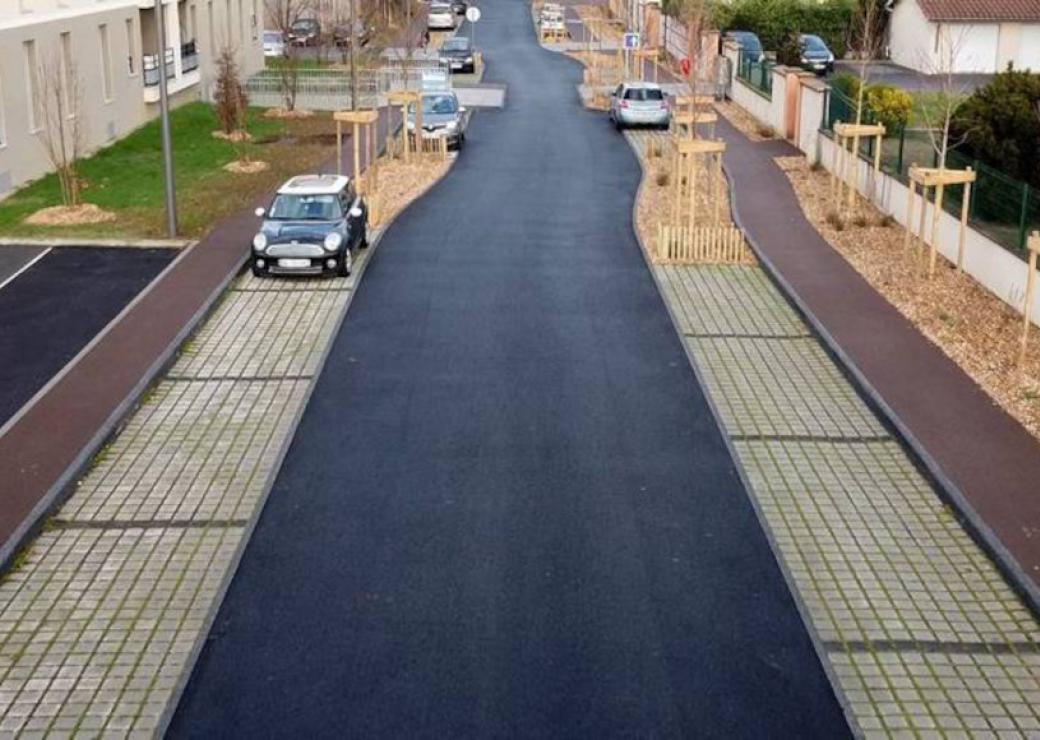 Vue d'une rue nouvellement aménagée: plantations et enrobé visiblement neufs