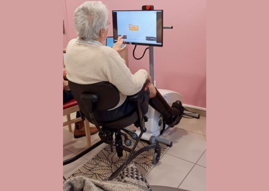 Une personne sur un vélo d'intérieur et face à un écran