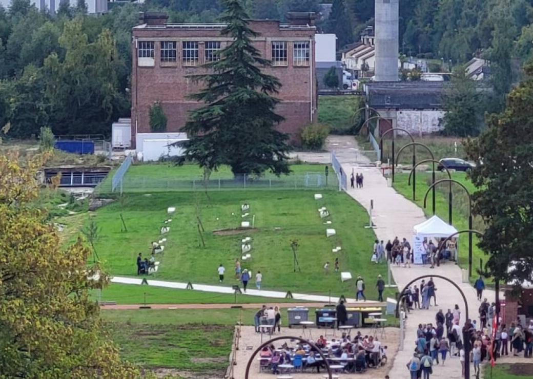 Vue aérienne d'un parc. AU fond, un bâtiment de briques rouges