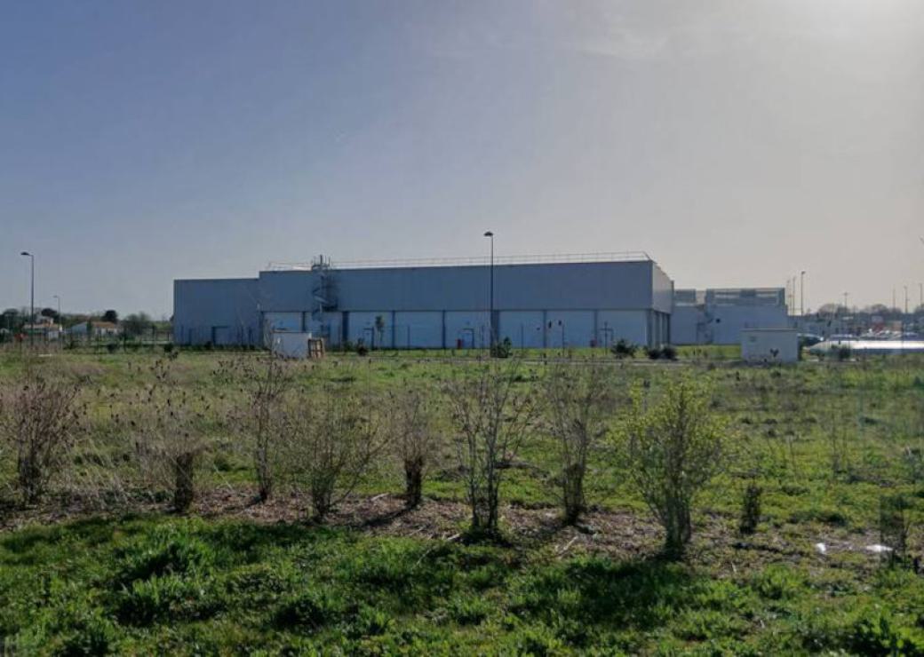 Un bâtiment industriel, et au premier plan, de la végétation tout juste plantée