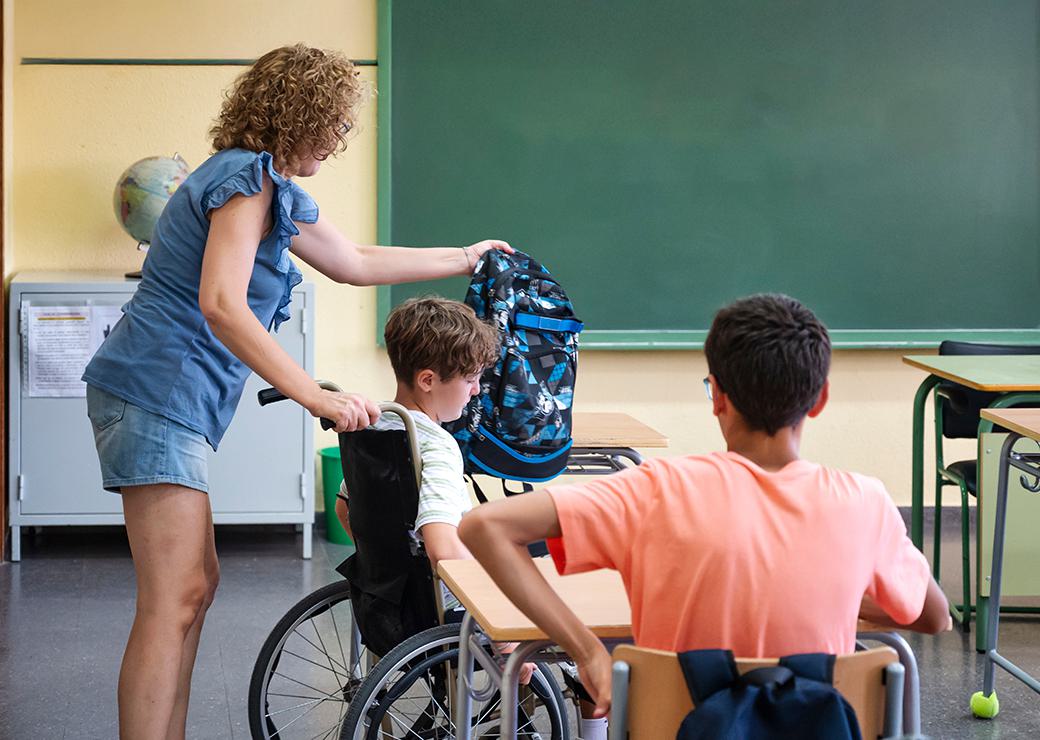 un enfant enfauteuil roulat en classe