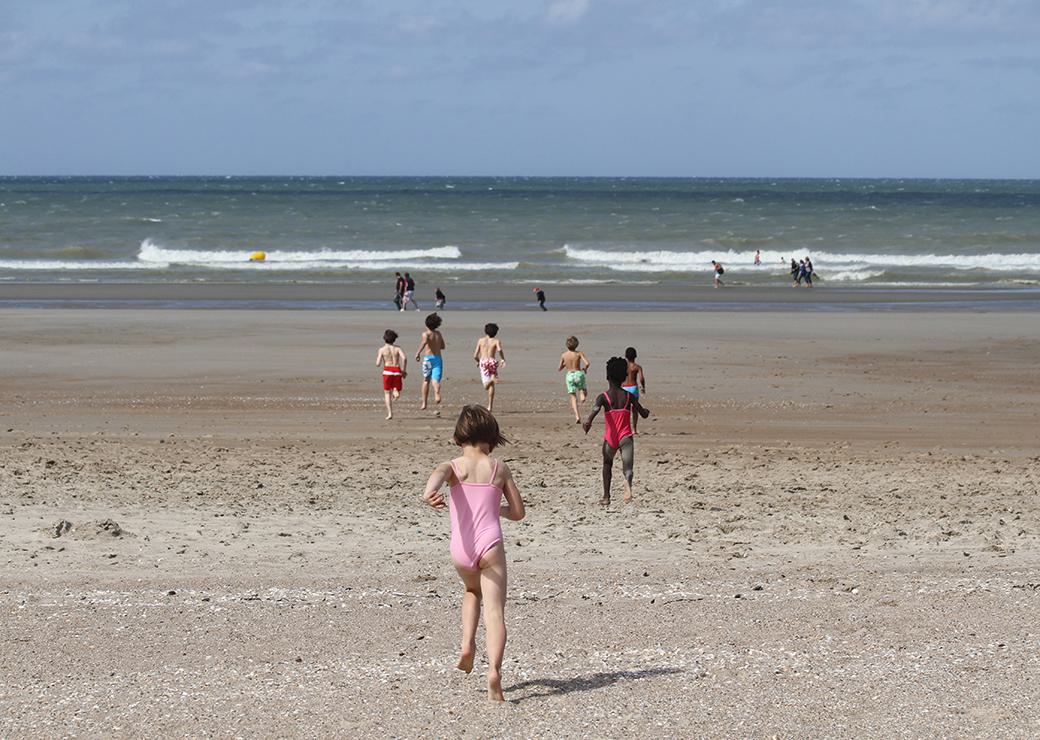 un groupe d'enfants court vers la mer 