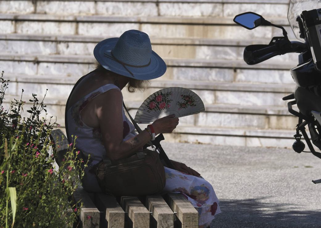 une femme à l'ombre avec son eventail 