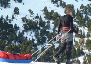 Skieur de randonnée nordique tractant une pulka en plastique dans le massif du Vercors (France) 