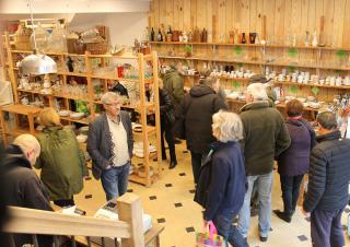 Plusieurs personnes regardent des objets dans une salle aux murs couverts d'étagères