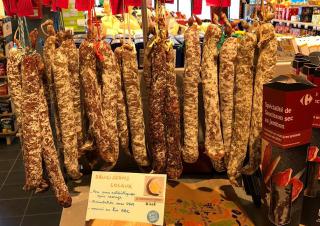 Rangée de saucissons suspendus, exposés dans un magasin