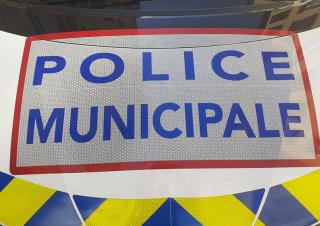 Zoom sur le logo police municipale sur le capot d'une voiture