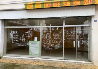 Photo d'une vitrine sur laquelle on peut lire "atelier boutique", accompagné de dessins