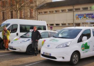 Deux personnes posent devant des véhicules siglés de logos colorés