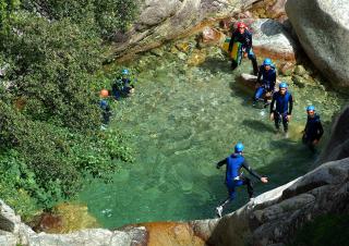 Des personnes en combinaison de plongée sont immergés dans une eau turquoise