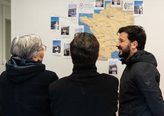 Trois personnes regardent une carte de France