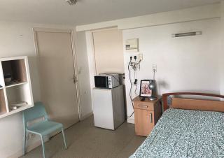 Une chambre simple avec une dessus de lit bleu
