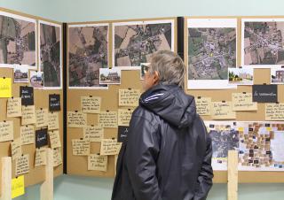 Une personne prend connaissance de documents affichés sur des portants